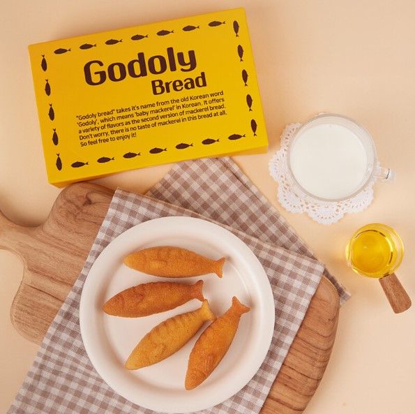 노란 Godoly Bread 박스와 우유, 접시 위의 고도리빵